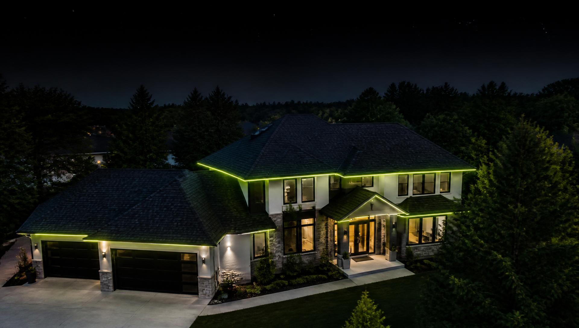 Aerial view of a well-kept home at dusk with lime-accent lighting